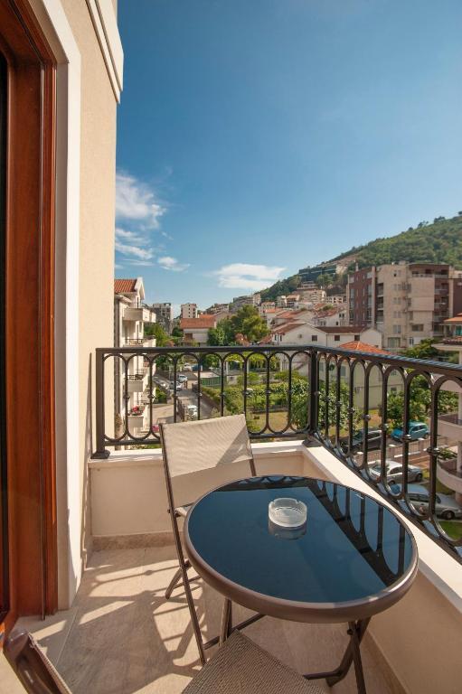 a balcony with a table and a view of a city at Hotel Villa Gracia in Budva