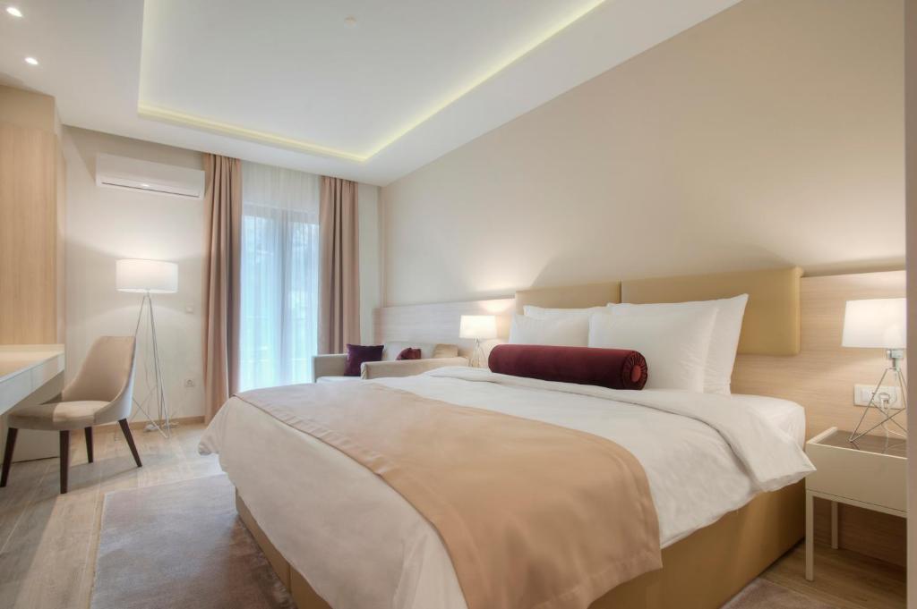 a hotel room with a large bed and a desk at Hotel Villa Gracia in Budva