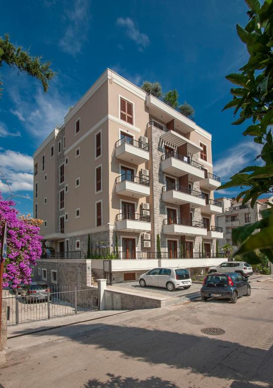 a tall building with cars parked in front of it at Hotel Villa Gracia in Budva