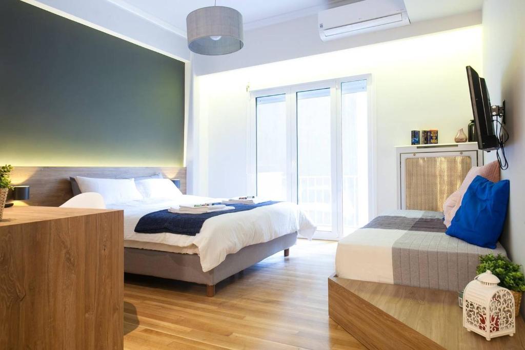 - une chambre avec un lit, une télévision et une fenêtre dans l'établissement TONI'S Lovely Retreat Studio for couples in Centre, à Athènes