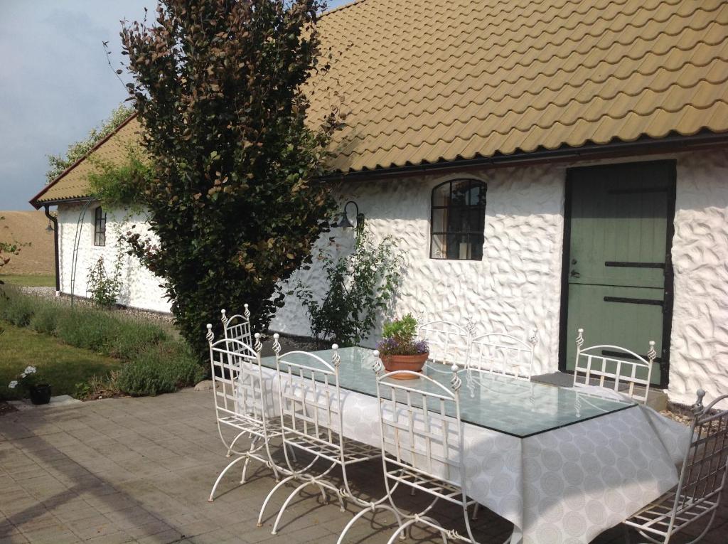 een tafel en stoelen voor een huis bij Stallet på Skårby in Ystad