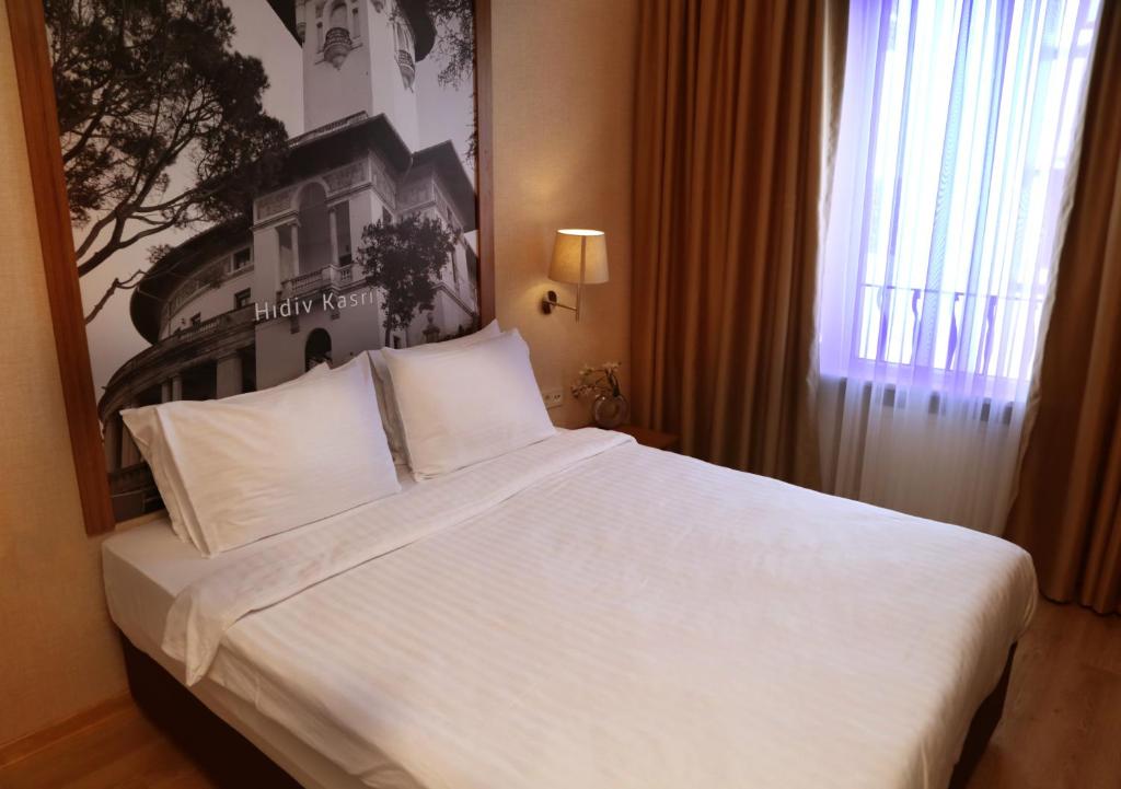 イスタンブールにあるSisli MLS Hotelのホテルルーム内の大きな白いベッド