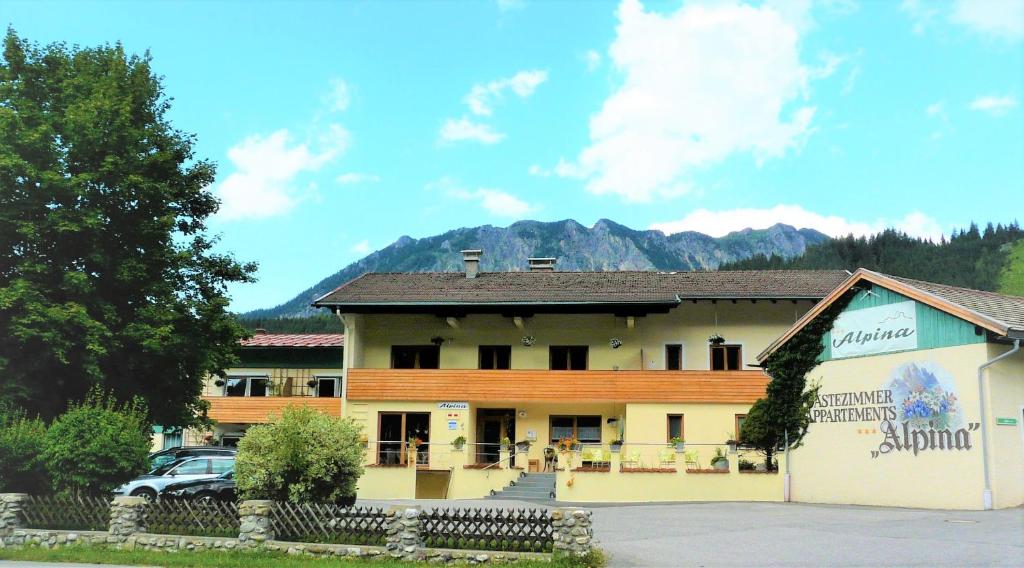 un bâtiment avec une voiture garée devant lui dans l'établissement Alpina Appartements, à Haldensee