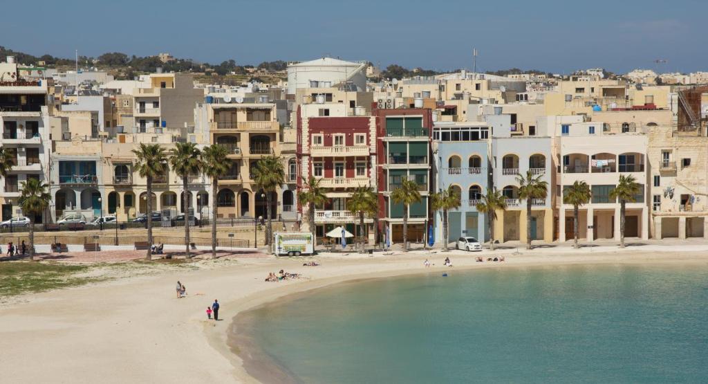 a view of a beach in front of a city at Water's Edge Hotel in Birżebbuġa