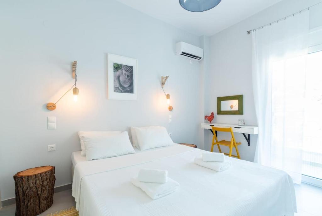 依拉佩特拉的住宿－Rodamos apartment，一间白色卧室,配有两张床和一张书桌