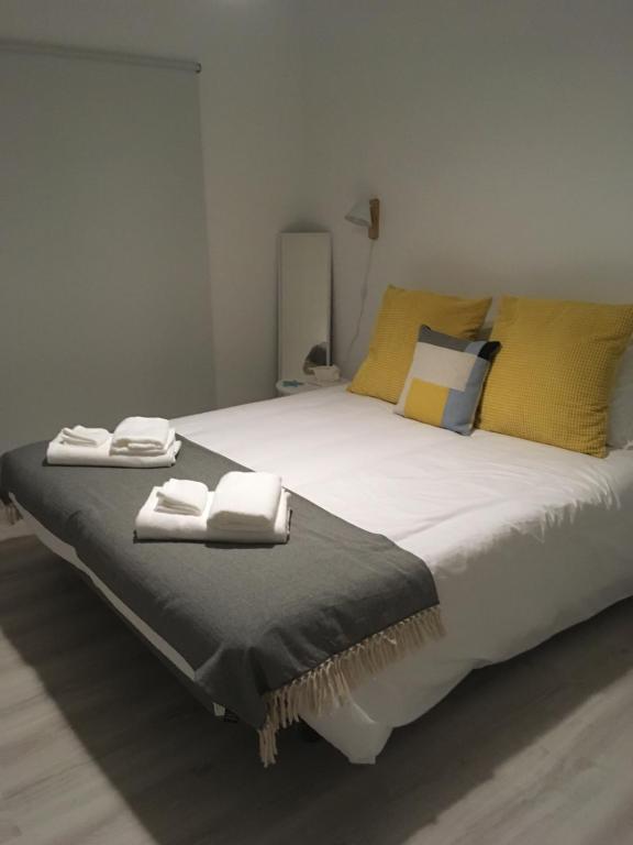 una camera da letto con un grande letto con asciugamani di Salty House - Casa Salgada a Foz do Arelho