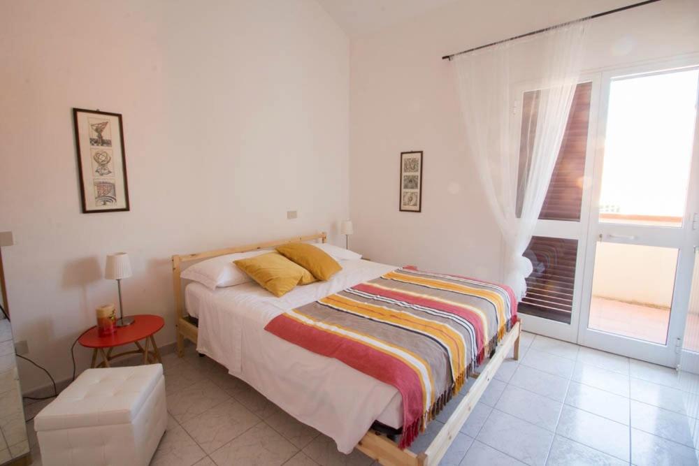 a white bedroom with a bed and a window at Villa Galilei Rooms in Pisa