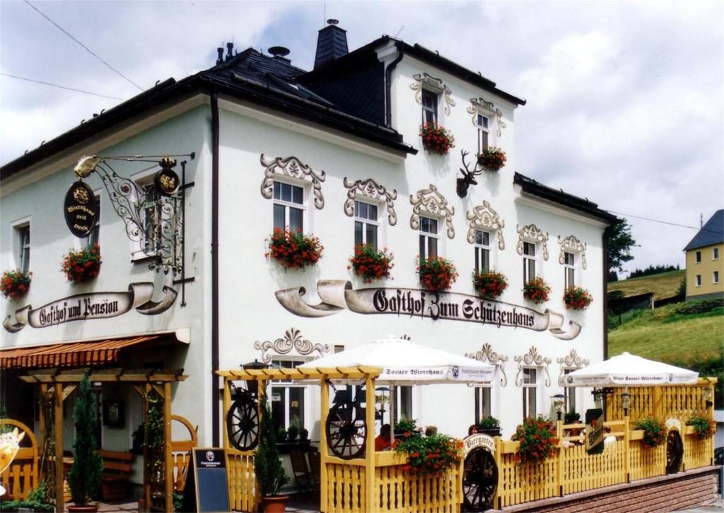 Ein weißes Gebäude mit einem Schild drauf. in der Unterkunft Landgasthof Zum Schützenhaus Sosa in Eibenstock