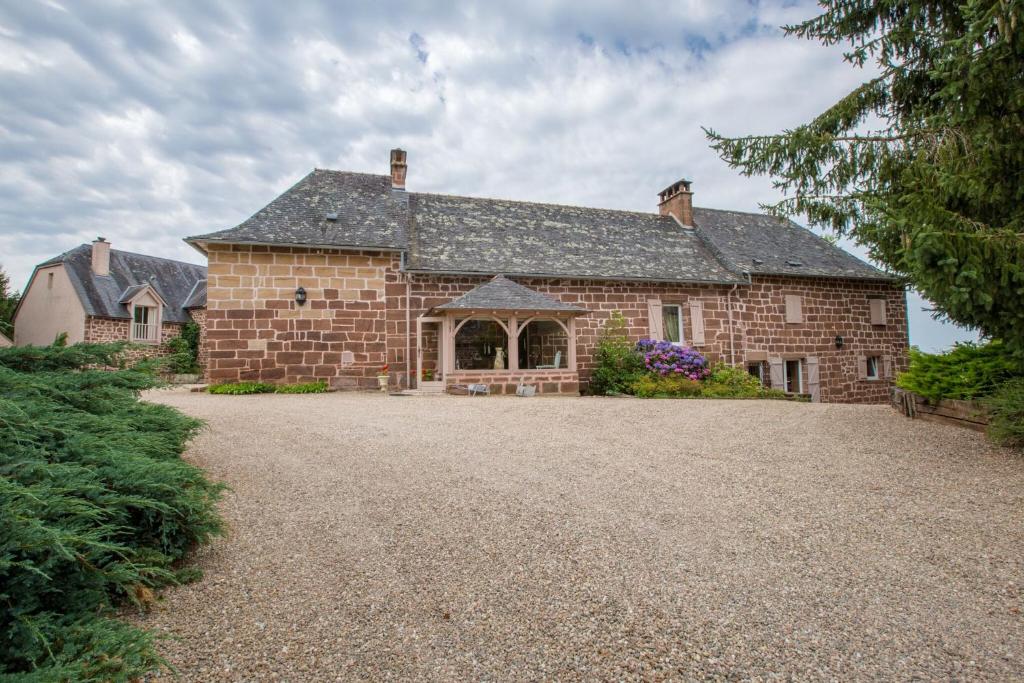 a large brick house with a large driveway at Le clos de rose in Ussac