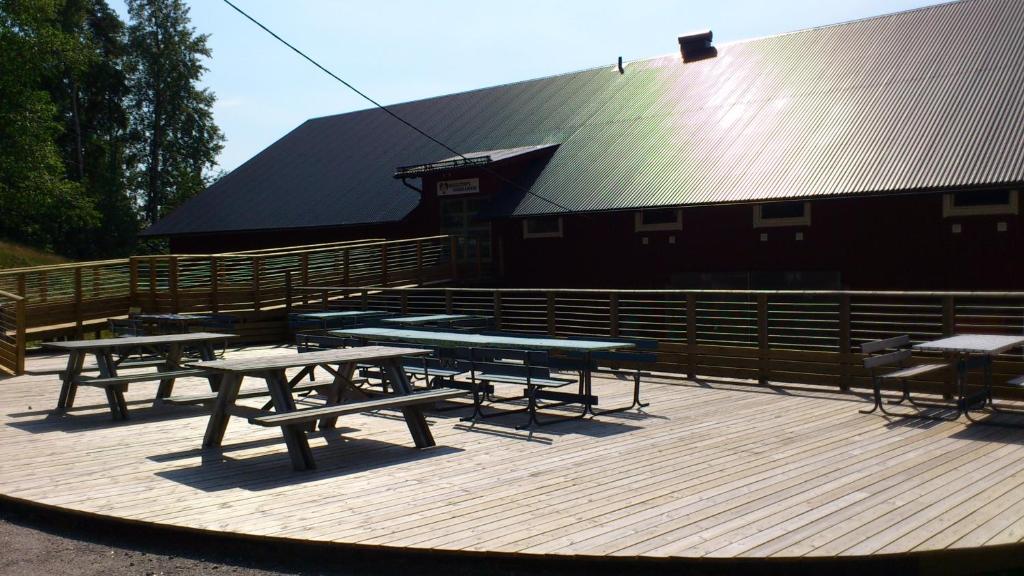 a group of picnic tables in front of a building at Baggetorps Vandrarhem in Vallhalla