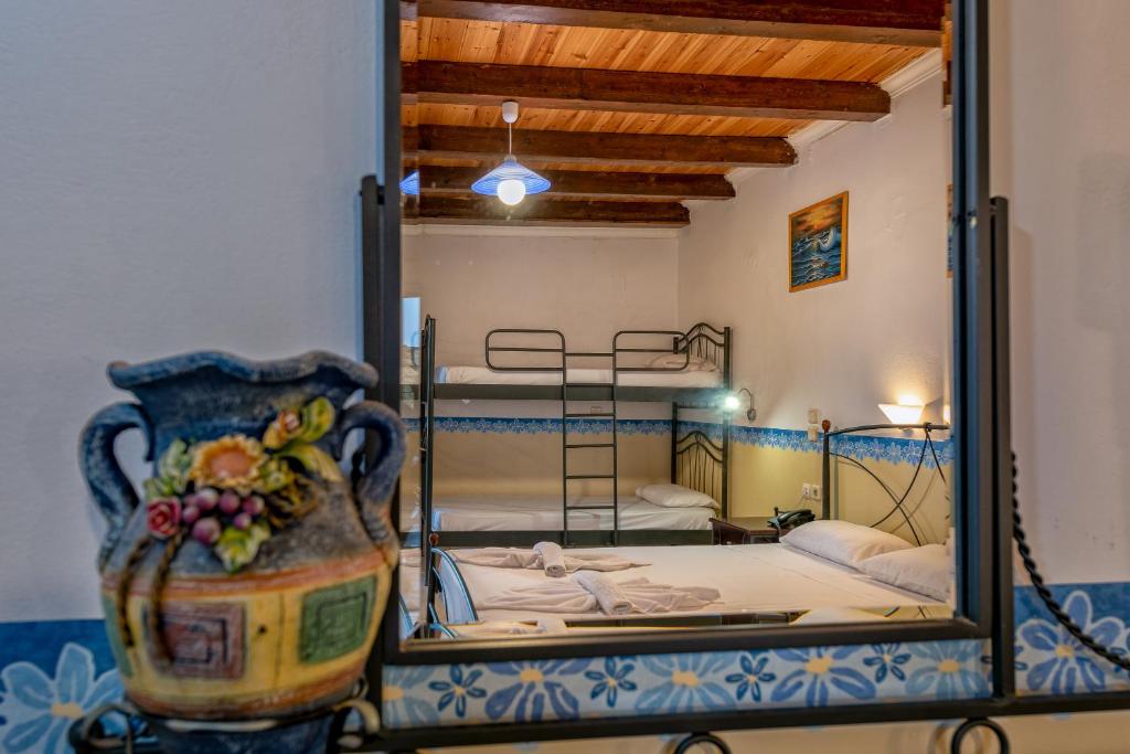 a bedroom with two bunk beds and a mirror at Tsiolis Studios & Apartments in Tsilivi