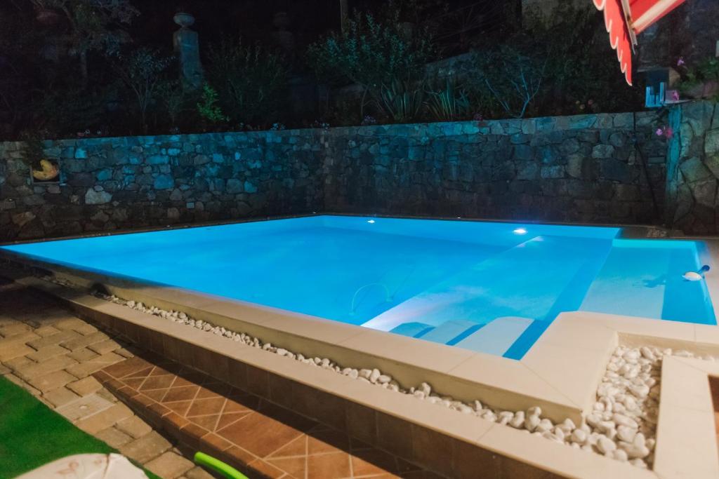 - une piscine avec un mur en pierre la nuit dans l'établissement Chiaro di Luna, à Villammare