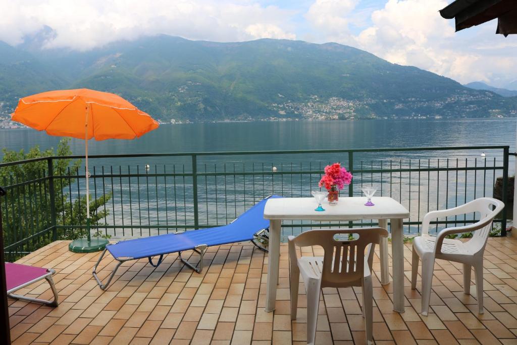 a table and chairs on a balcony with a view of the water at Casa al Lago Trentuno B in Zenna