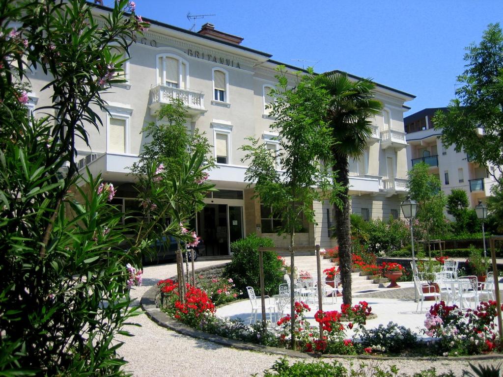 un edificio con un jardín delante de él en Hotel Britannia, en Cesenatico