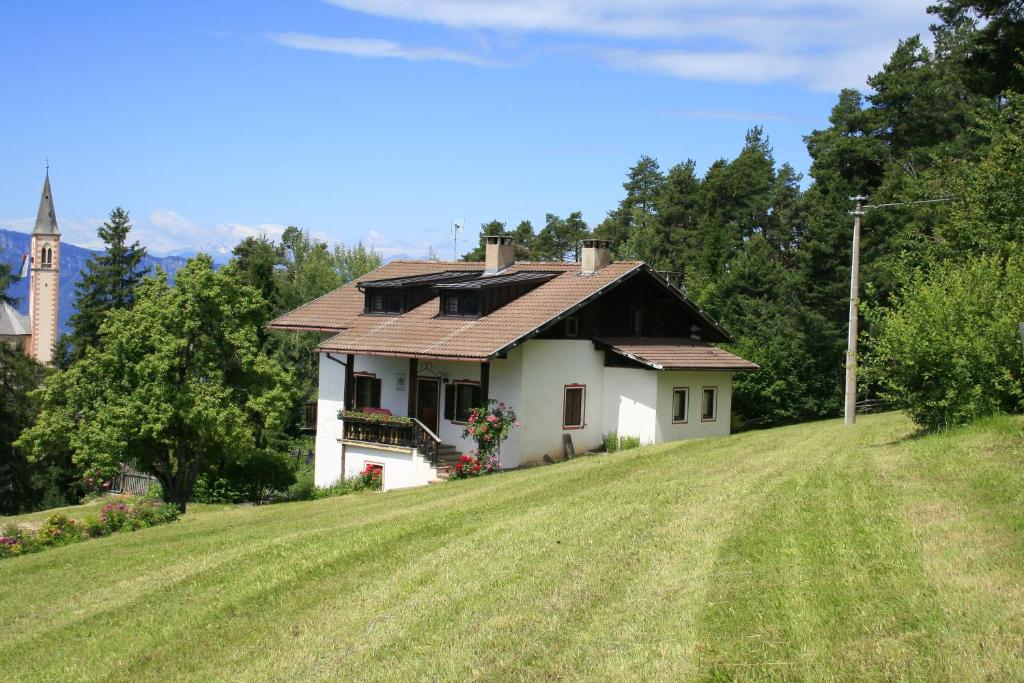 uma pequena casa branca numa colina com uma igreja em Finhäusl - Urlaub bei Oma em Aldino