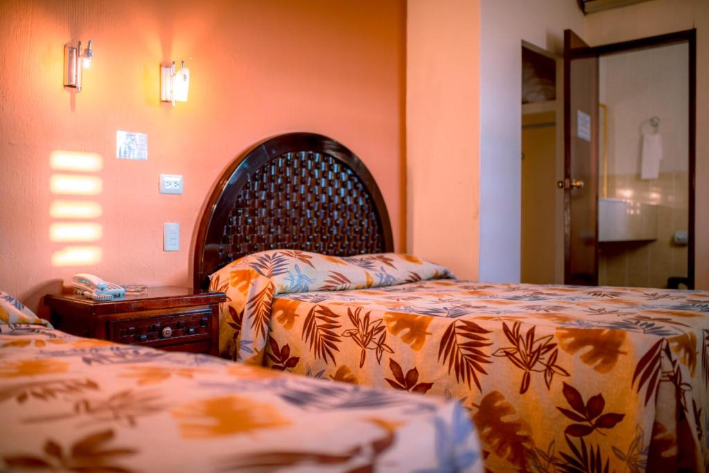 a bedroom with two beds and a head board at Hotel Los Girasoles in Tepic