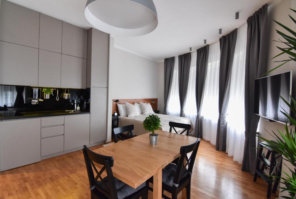 a living room with a table and a bed at Karlo Main Square Apartments in Zagreb