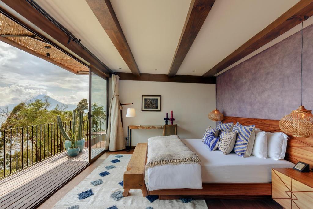 een slaapkamer met een bed en een balkon bij Hotel Casa Palopo in Santa Catarina Palopó