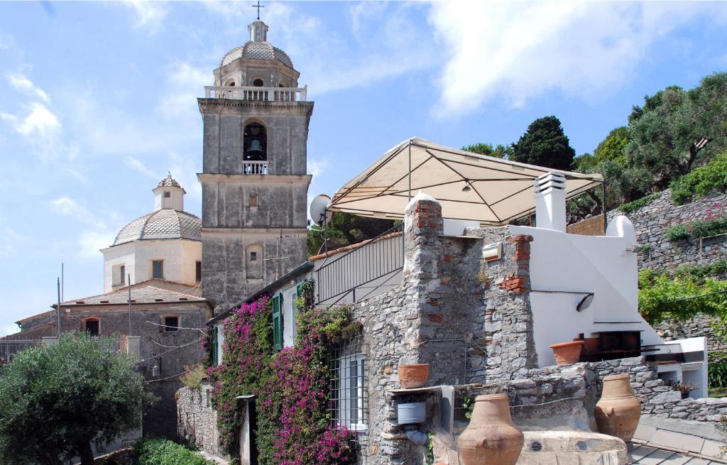 um edifício antigo com uma torre de relógio numa colina em La BouganVilla em Portovenere