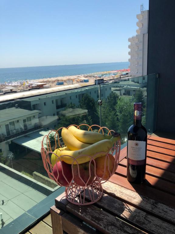 un cesto di banane e una bottiglia di vino sul balcone di Sea View Mamaia a Mamaia