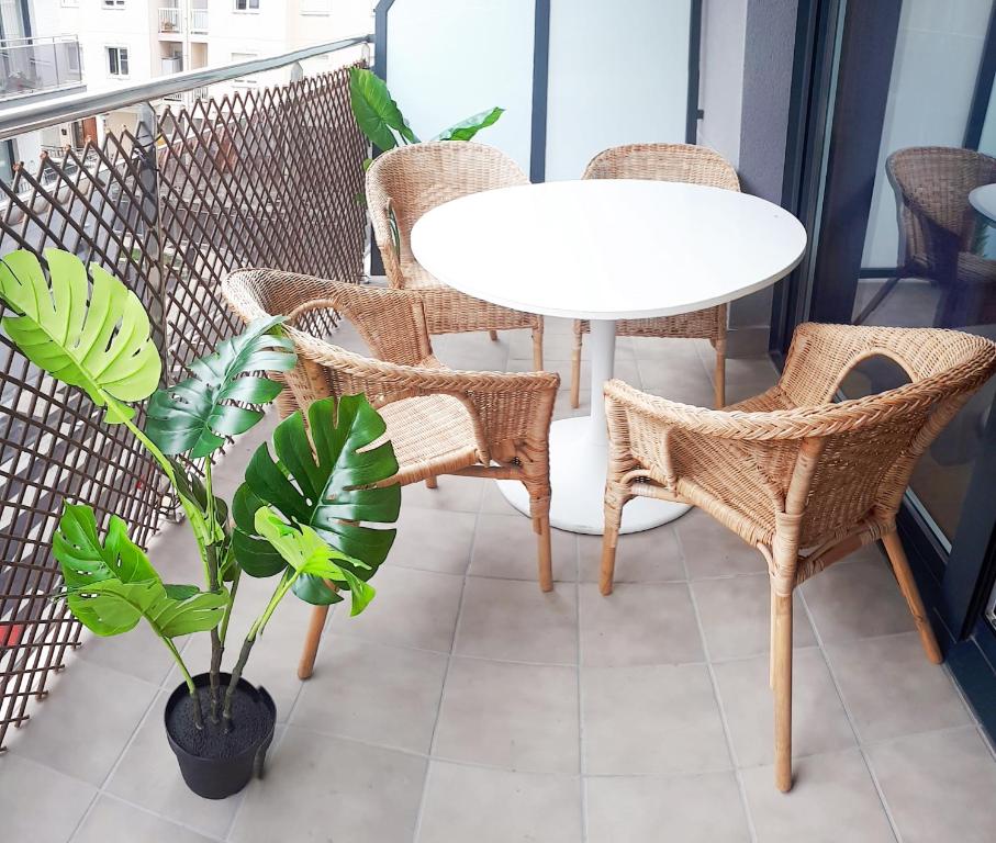 a balcony with a table and chairs and a plant at Telmo's Home con PARKING in Zumaia