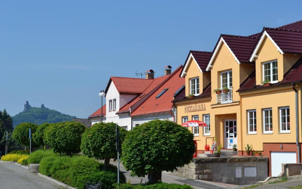 eine Reihe von Häusern mit roten Dächern auf einer Straße in der Unterkunft U Rozhovoru in Rovensko pod Troskami