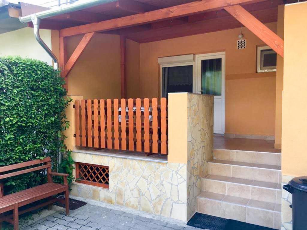 a porch with a wooden fence and a bench at Apartman Marina in Bük