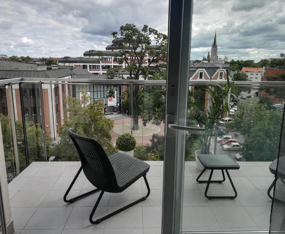a balcony with two chairs and a view of a city at Apartament Neptun in Olsztyn