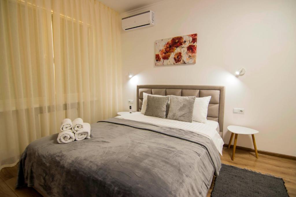 a bedroom with a bed with two towels on it at Osokorky Delux Apartment in Kyiv
