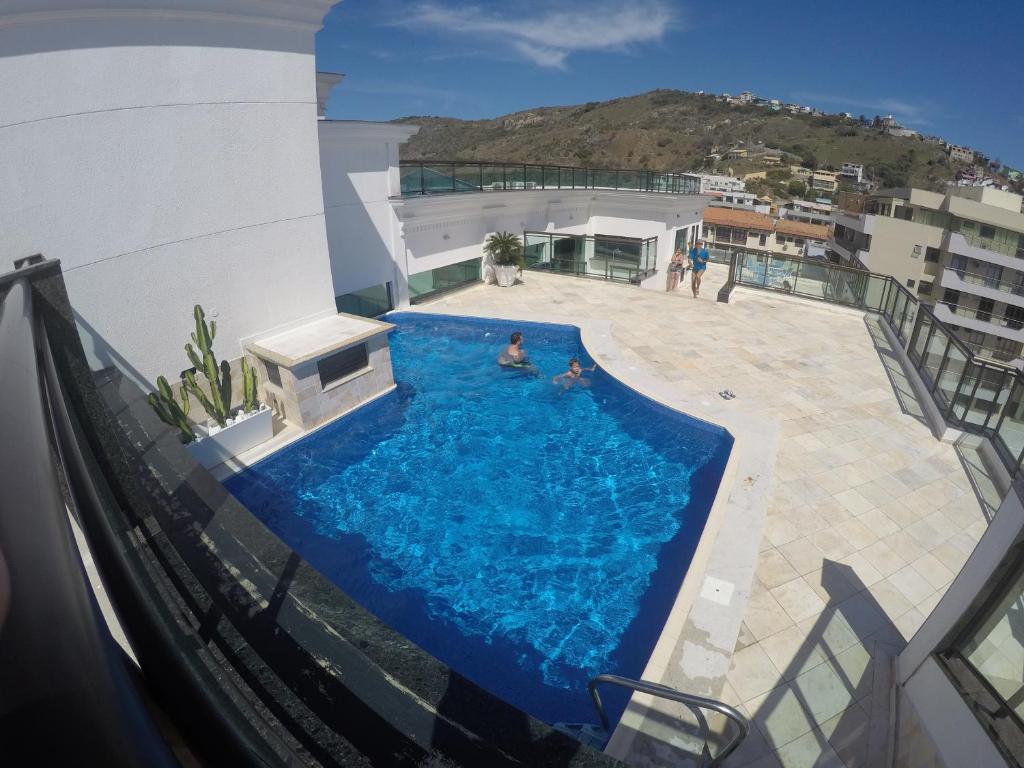 una piscina al lado de un edificio en Loft Prainha, en Arraial do Cabo