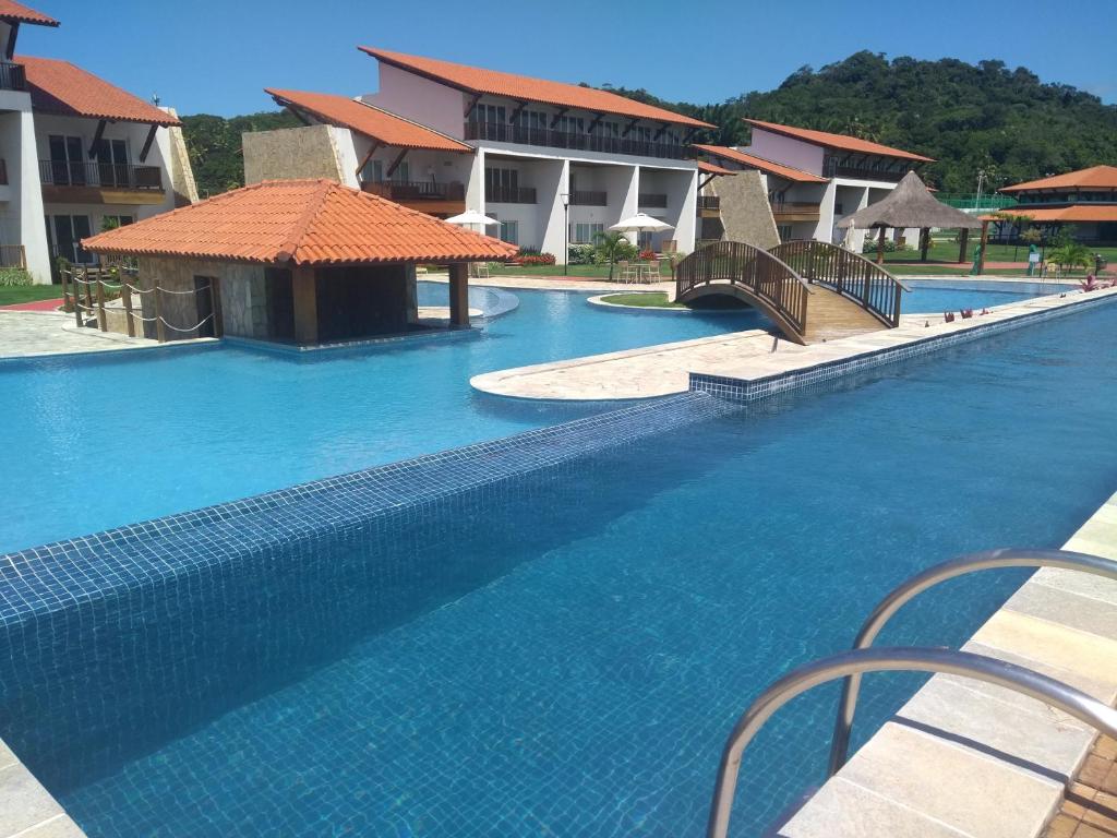 einen Pool mit blauem Wasser in einem Resort in der Unterkunft Flat Club Meridional in Tamandaré