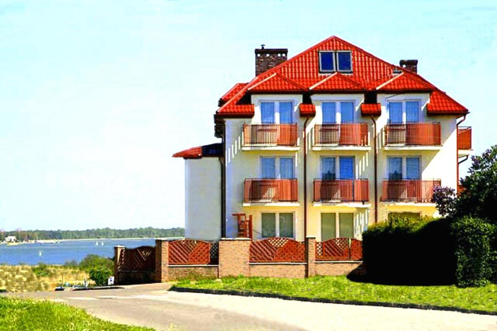 a large house with a red roof on a street at Rades in Władysławowo