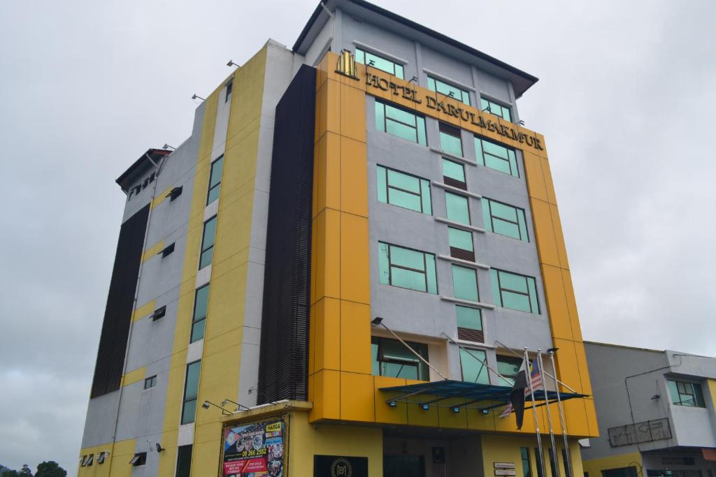 a yellow and gray building with a sign on it at Hotel DarulMakmur Jerantut in Jerantut