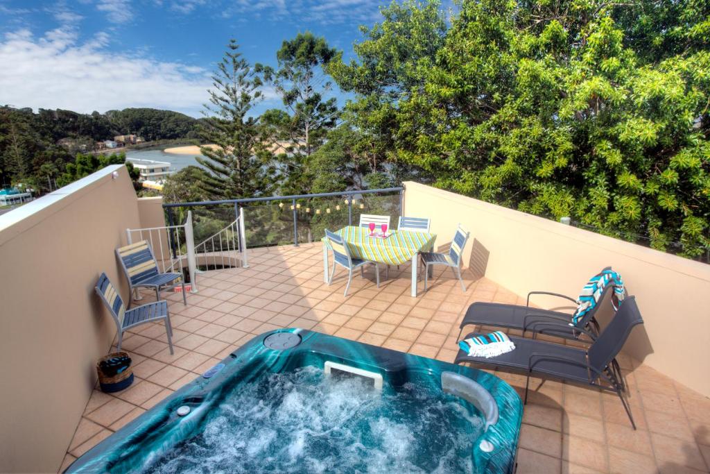 a hot tub on a patio with a table and chairs at oceanview 6 with rooftop terrace & spa in Nambucca Heads