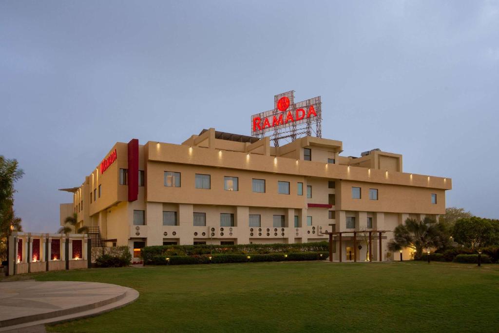 a building with a neon sign on top of it at Ramada Ajmer in Kishangarh