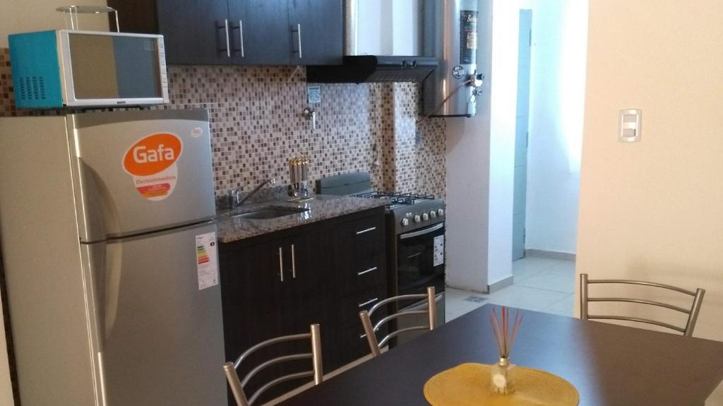 una cucina con frigorifero e tavolo con sedie di Departamento Andino del Sol a San Juan