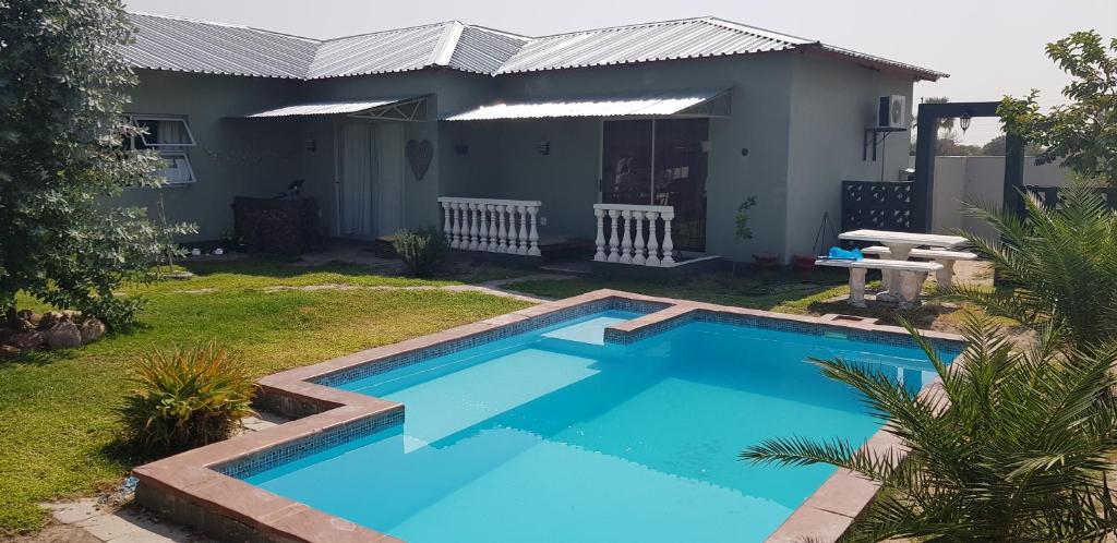 a swimming pool in front of a house at Villa Graf in Ongwediva