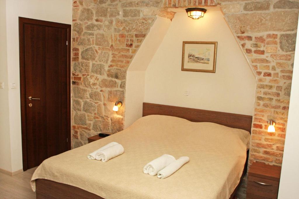 ein Schlafzimmer mit einem Bett mit zwei Handtüchern darauf in der Unterkunft Apartments Centrum Split in Split