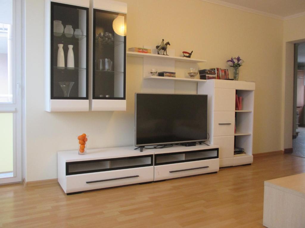 a white entertainment center with a flat screen tv at Adoria in Giżycko