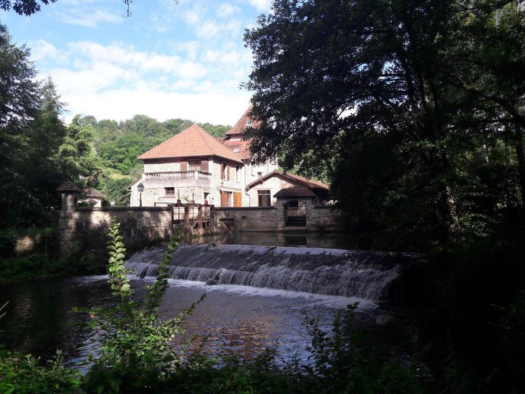 een huis midden in een rivier met een waterval bij Le moulin régnelot - Chambre d'hôtes in Verdelot