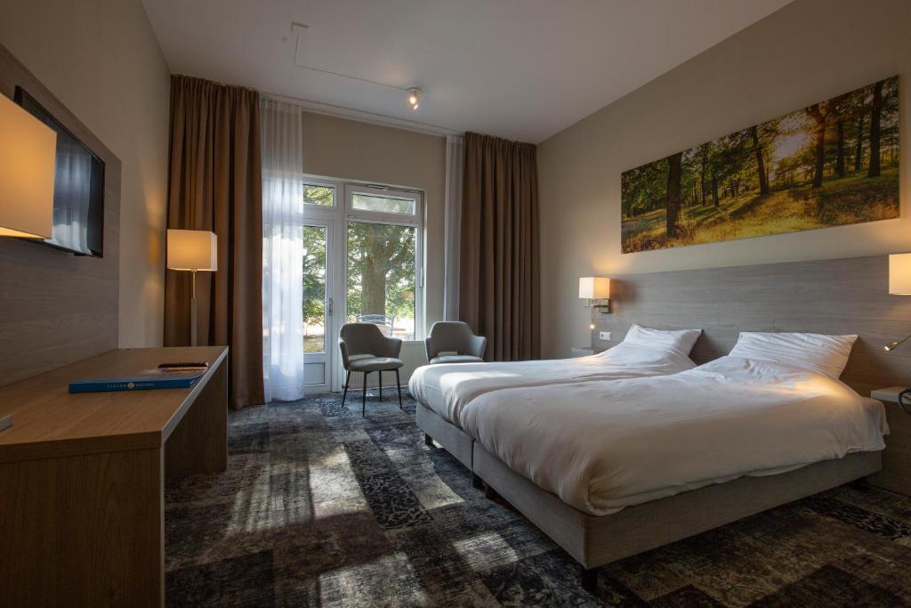 Postel nebo postele na pokoji v ubytování Fletcher Hotel-Restaurant Paasberg