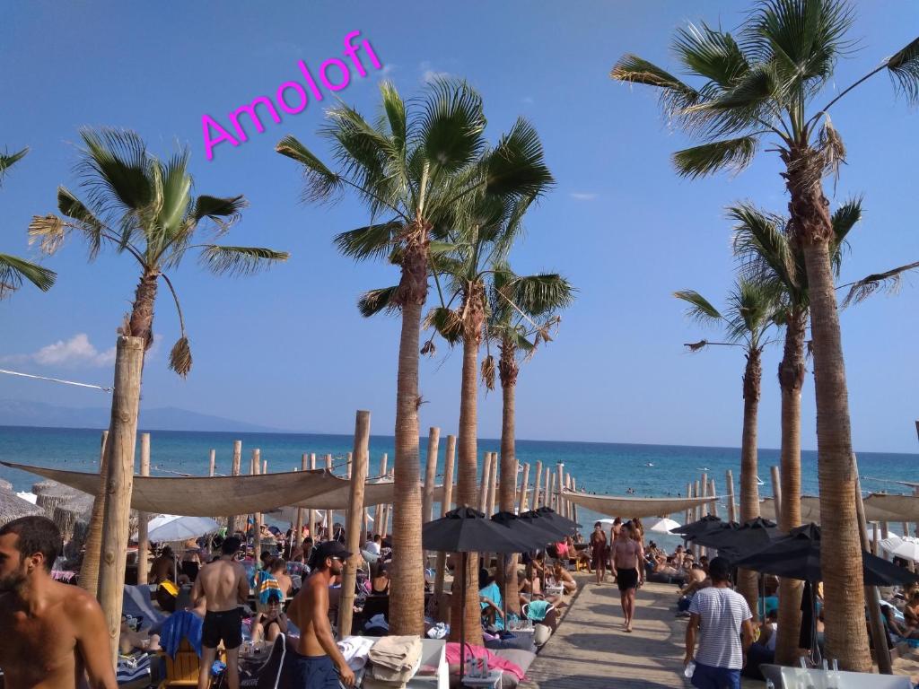 Une foule de gens sur une plage avec des palmiers dans l'établissement Evris House 1, à Kavala