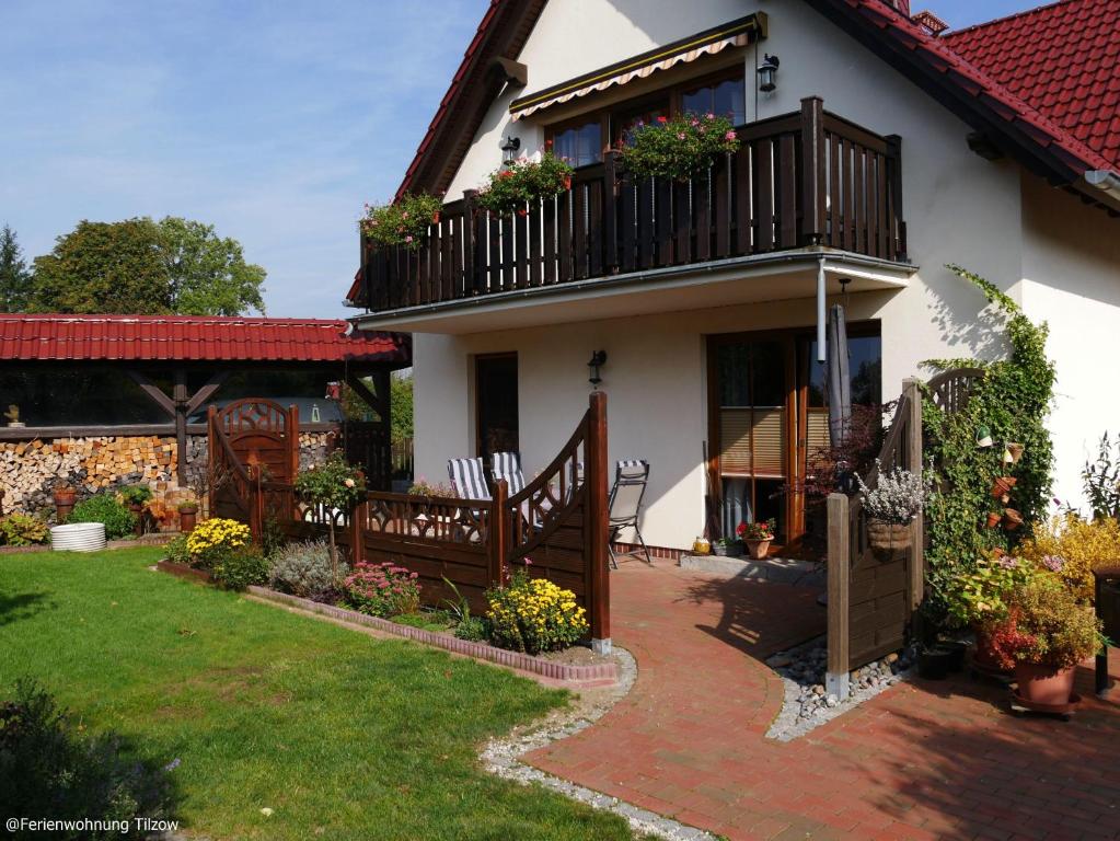 ein Haus mit einem Balkon und einem Hof in der Unterkunft Ferienwohnung "  An der Koppel " in Mölln-Medow