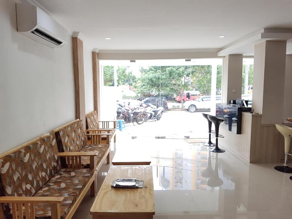 a room with benches and a table and some motorcycles at Ethan Hotel Kelapa Gading in Jakarta