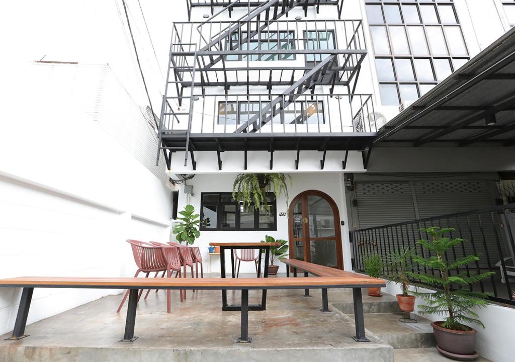 Apartment45 Hostel في بانكوك: فناء مع طاولة وكراسي في مبنى