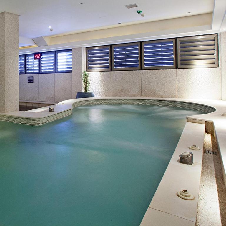 a swimming pool with blue water in a building at Beitou Sweet Me Hot Spring Resort in Taipei