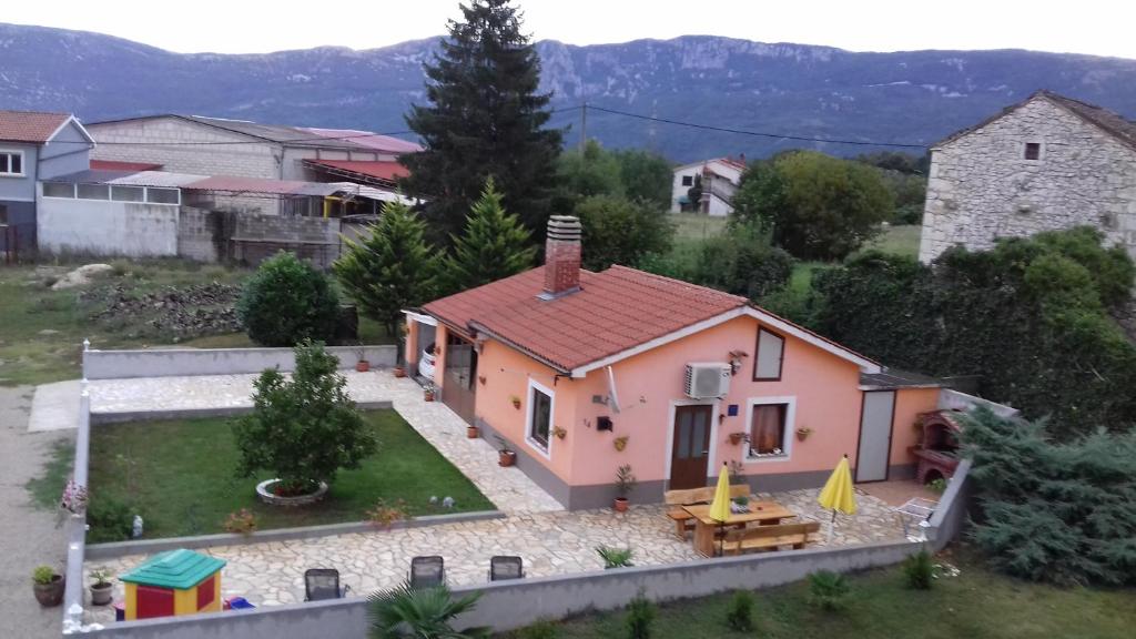 a small pink house with a table in a yard at Holiday Home Izabela in Kršan