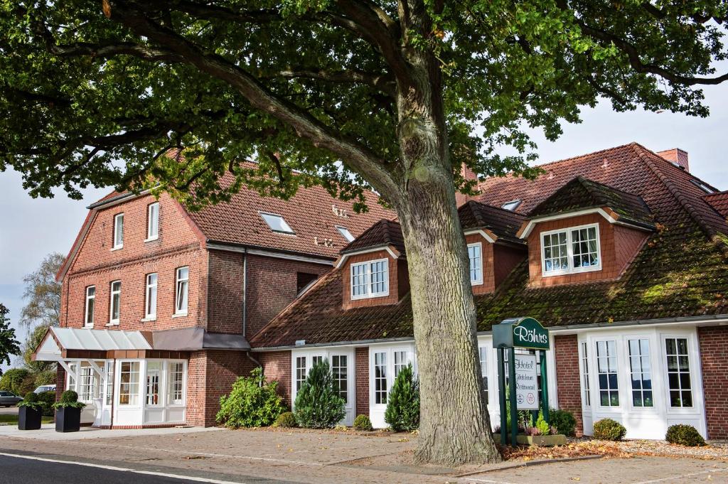 una casa de ladrillo con un árbol delante de ella en Hotel Röhrs, en Visselhövede