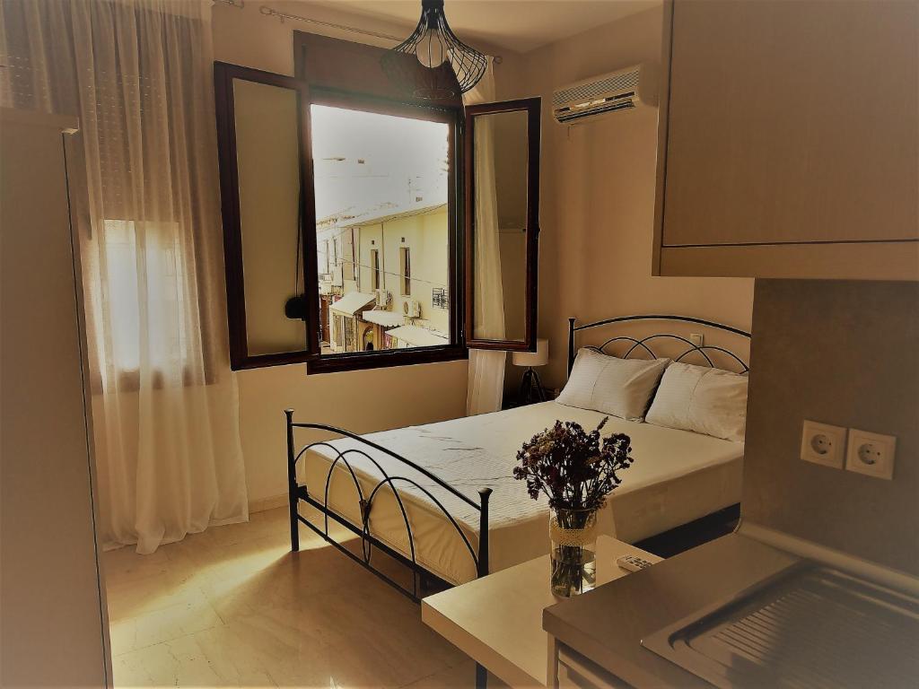 Dormitorio pequeño con cama y espejo en Prokymaia Apartment 2, en Áyios Andónios
