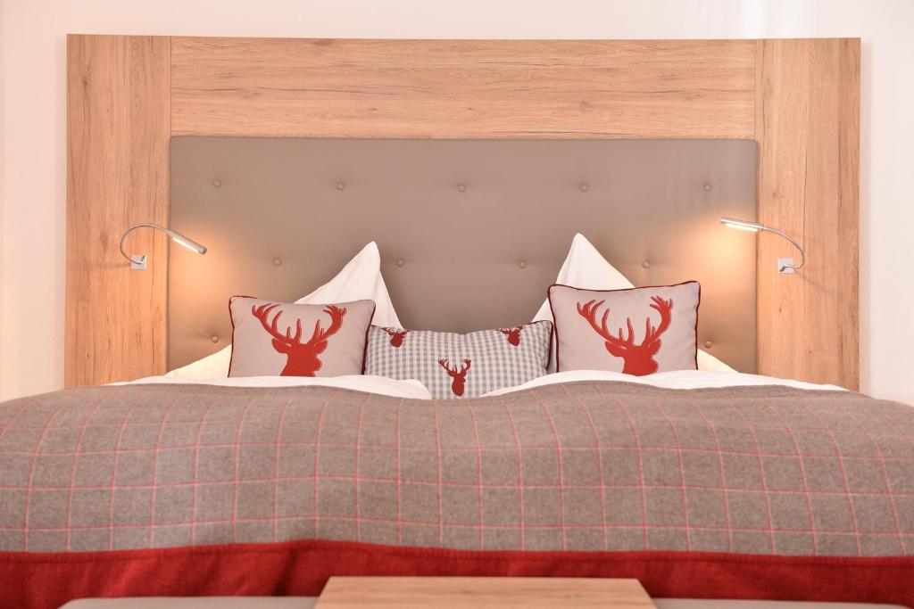 a bedroom with a bed with two red antlers on it at Hotel Kaiserpfalz in Paderborn